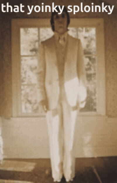 Man In Suit Playing Piano While Woman In Black Dress Dancing GIF