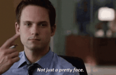 Man In Suit Pointing At Ear Saying Not Just A Pretty Face GIF