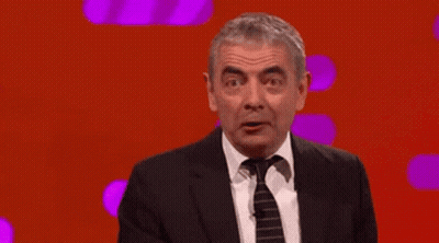 Man In Suit Pointing Up Saying It's Mr. Bean GIF