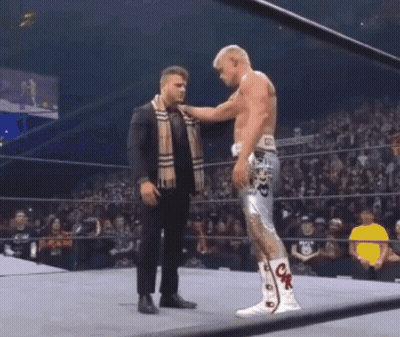 Man In Suit Putting Scarf On Wrestler GIF