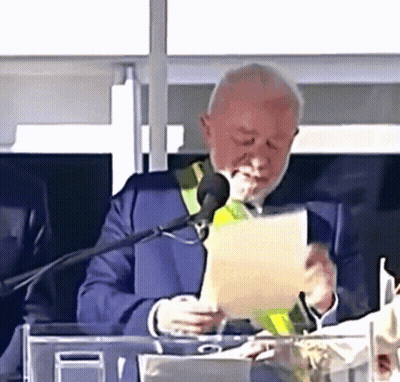 Man In Suit Reading Paper At Microphone GIF