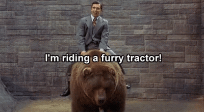 Man In Suit Riding Furry Tractor On Bear GIF
