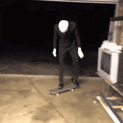 Man In Suit Riding Skateboard In Garage GIF