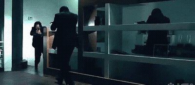 Man In Suit Running In Dark Room GIF