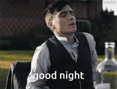 Man In Suit Saying Good Night At Table With Alcohol GIF