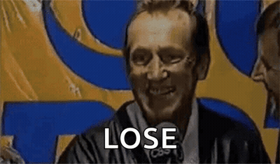 Man In Suit Saying Lose In Front Of Yellow And Blue Sign GIF