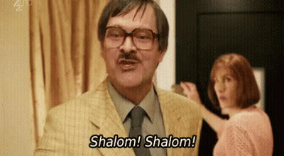 Man In Suit Saying Shalom Shalom With Woman Behind GIF