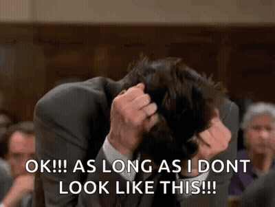 Man In Suit Scratching Head In Courtroom GIF