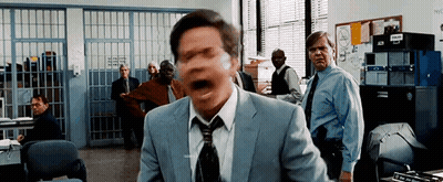 Man In Suit Screaming In Police Station With Group Behind Him GIF