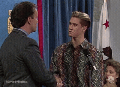 Man In Suit Shaking Hands With Man In Colorful Shirt GIF