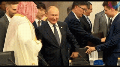 Man In Suit Shaking Hands With Man In White Robe GIF