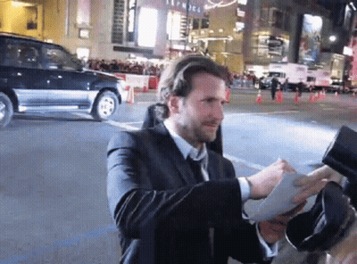 Man In Suit Signing Autographs For Fans GIF