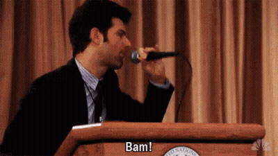 Man In Suit Singing Into Microphone At Podium GIF