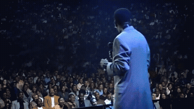 Man In Suit Singing Into Microphone In Front Of Crown GIF