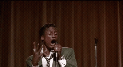 Man In Suit Singing Into Microphone On Stage GIF