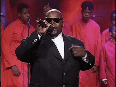 Man In Suit Singing Into Microphone With Choir GIF