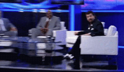 Man In Suit Sits On TV Set GIF