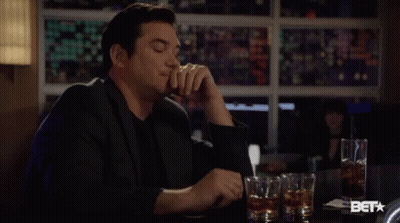 Man In Suit Sitting At Bar With Whiskey GIF
