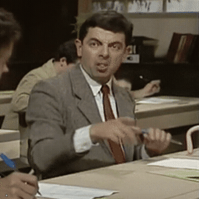 Man In Suit Sitting At Desk In Classroom GIF