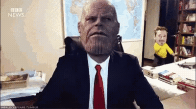 Man In Suit Sitting At Desk In Front Of BBC News Map GIF