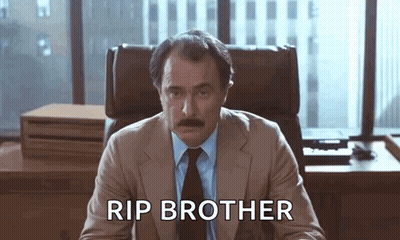 Man In Suit Sitting At Desk Rip Brother GIF
