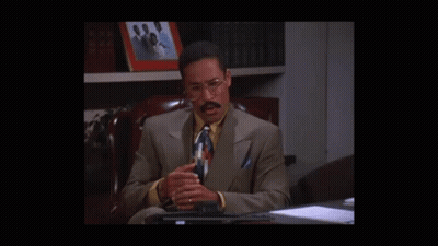 Man In Suit Sitting At Desk Talking GIF