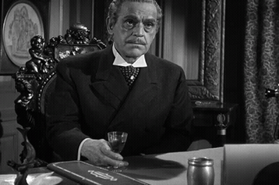 Man In Suit Sitting At Desk With Glass GIF
