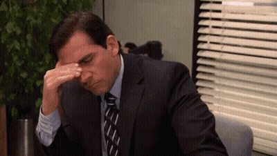 Man In Suit Sitting At Desk With Hand On Forehead GIF