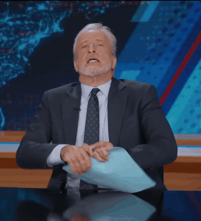Man In Suit Sitting At Desk With Hands On Head GIF