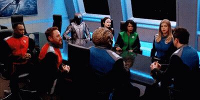 Man In Suit Sitting At Table Before Crowd GIF