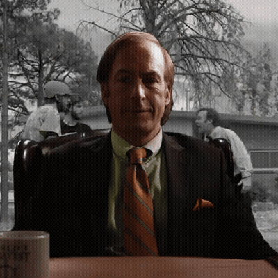 Man In Suit Sitting At Table With Bad Ass Mug GIF