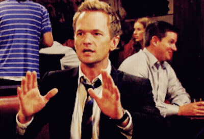 Man in Suit Sitting at Table With Hands Up