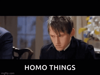 Man In Suit Sitting At Table With Homo Things Sign GIF