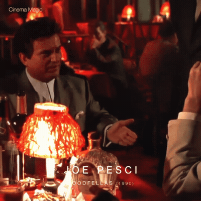 Man In Suit Sitting At Table With Red Lamp Joe Pesci GIF