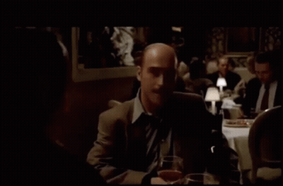 Man In Suit Sitting At Table With Wine And Beer GIF