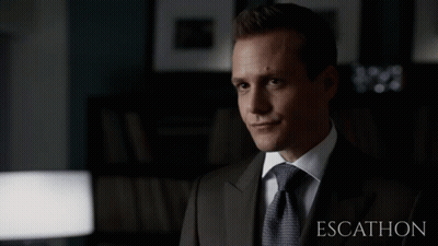 Man In Suit Sitting Before Escalhon Sign GIF