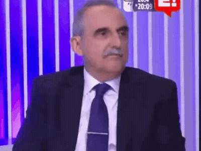 Man In Suit Sitting Before Purple Striped Wall GIF