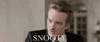 Man in Suit Sitting Before Snooty Wall