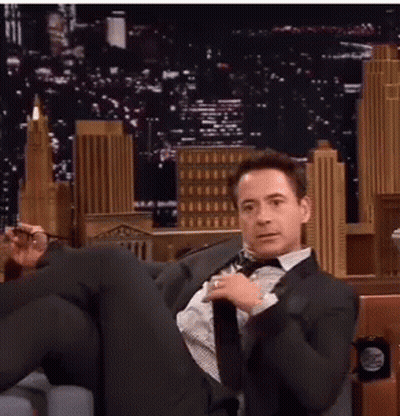 Man In Suit Sitting Cross-Legged GIF