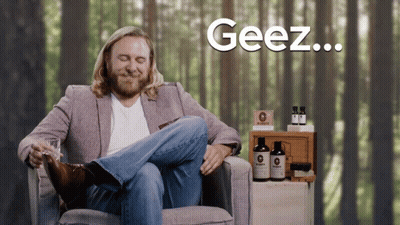 Man In Suit Sitting Cross-Legged Saying Geez GIF