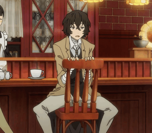 Man In Suit Sitting In Chair In Front Of Counter GIF
