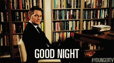 Man In Suit Sitting In Front Of Bookshelf Good Night GIF