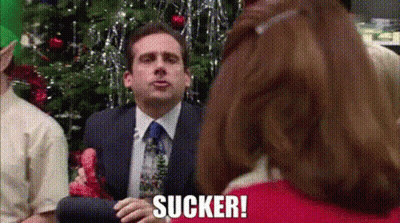 Man In Suit Sitting In Front Of Christmas Tree With Woman Behind GIF