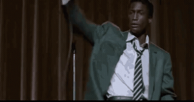 Man In Suit Sitting In Front Of Crowd GIF