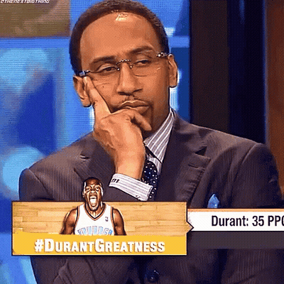 Man In Suit Sitting In Front Of #Durantgreatness Sign GIF