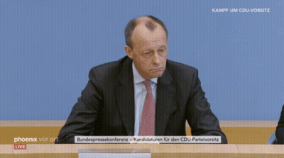 Man In Suit Sitting In Front Of Phoenix Vor Ort Live Screen GIF