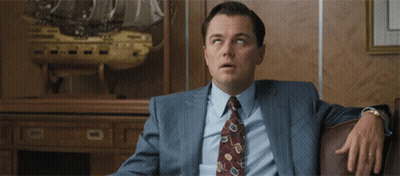 Man In Suit Sitting In Front Of Ship Model GIF