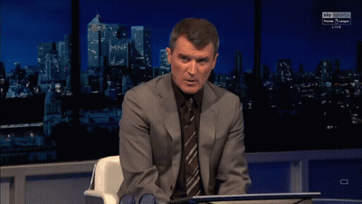 Man In Suit Sitting In Front Of Sky Sports Sign GIF