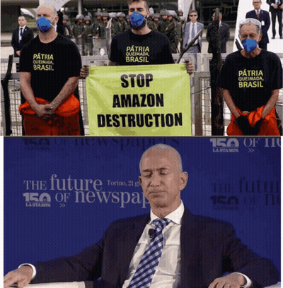 Man in Suit Sitting in Front of Stop Amazon Destruction Sign