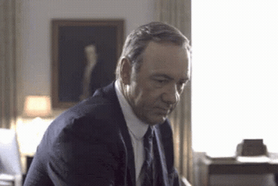 Man In Suit Sitting In Front Of Window GIF